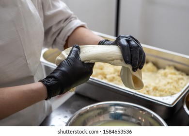 Artisan Cheesemaker Cuts The Caciocavallo With Hands. Italian Hard Cheese Silano Or Caciocavallo In Cheesemaker Hands. The Home-made Cheese Maker Produces Handmade Caciocavallo.