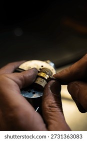Artisan fixing gold ring using precision tools in workshop