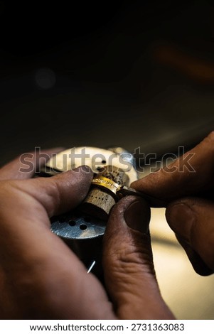 Artisan fixing gold ring using precision tools in workshop