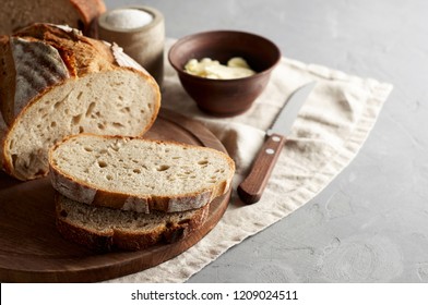 Artisan sliced toast bread with butter and sugar on wooden cutting board. Simple breakfast on grey concrete background. Closeup view - Shutterstock ID 1209024511