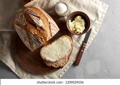 Artisan sliced toast bread with butter and sugar on wooden cutting board. Simple breakfast on grey concrete background. Top view - Shutterstock ID 1209024556