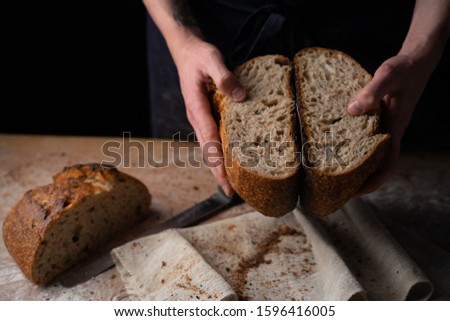 artisan sourdough bread cut (High Hydration Sourdough Bread). baker holding a loaf of bred