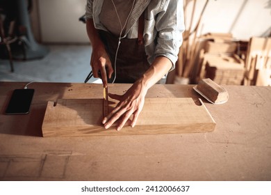 Artisan woman meticulously working on woodcraft in workshop