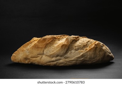 Artisanal rustic bread loaf on black background