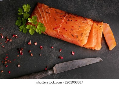 Artisanal smoked salmon on a slate board with red berries and a knife - Shutterstock ID 2201908387