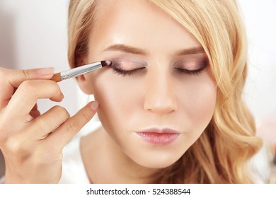 Artist Applying Eye Shadow On Beautiful Woman Eyes