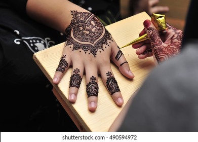 Artist Applying Henna Tattoo On Women Hands.