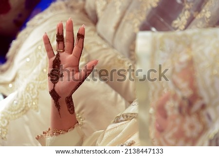 Artist applying henna tattoo on women hands. Mehndi is traditional moroccan decorative art. Close-up, top view
