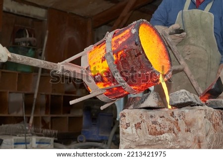 Artist casting melting bronze to make sculpture