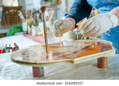 Artist creating clock in resin art technique. Woman wearing rubber gloves pouring liquid resin with pigments. Selective focus. - Powered by Shutterstock