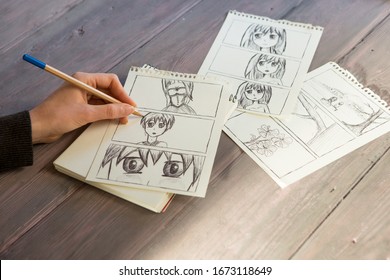 Artist Drawing An Anime Comic Book In A Studio. Wooden Desk, Natural Light