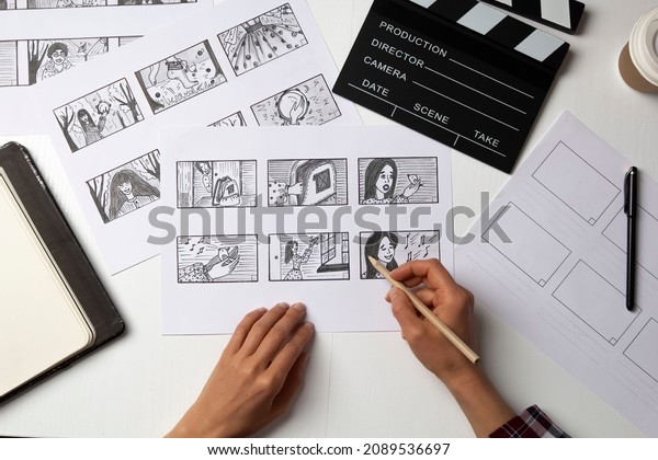 The artist draws a storyboard for the film. The\
director creates the storytelling by sketching footage of the\
script on paper.