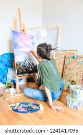 Artist Girl Painting Colorful Mountains On Canvas With Brush And Oil Paint Posing