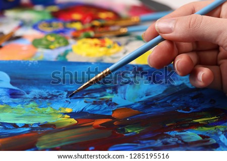Artist hand with brush painting picture close up. Art, creativity, hobby concept, Anti stress art therapy .