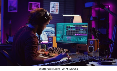 Artist improving the sound quality of audio recordings in home studio, handling mixing console and controls. Producer uses his creative vision to manipulate sounds, audio equipment. Camera B. - Powered by Shutterstock