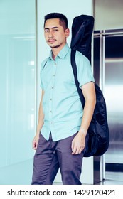 Artist Man Carrying A Guitar Case On The Shoulder In Room, Process Color.