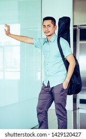 Artist Man Carrying A Guitar Case On The Shoulder In Room, Process Color.