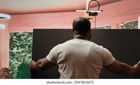 Artist is mixing different dye colors on a palette to create the perfect shade, creating a modern masterpiece on canvas. Male painter using creative tools and supplies for his artwork. Camera A. - Powered by Shutterstock