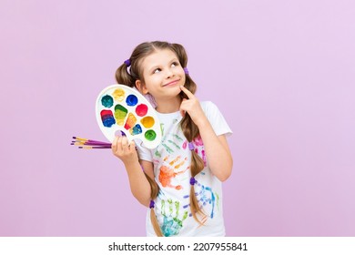 An artist on an isolated background, a little girl with paints in her hands, children's creativity.