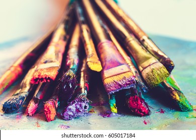 Artist paintbrushes with paint closeup on artistic canvas. Retro toned. Selective focus. - Powered by Shutterstock