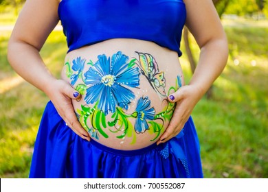 The artist painted flowers the belly pregnant women  On the body the woman painted cornflowers