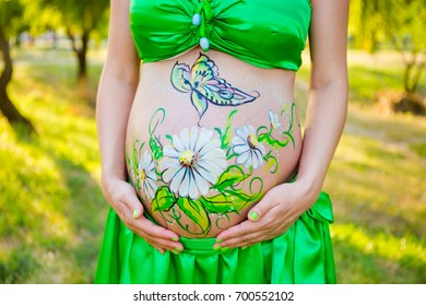 The artist painted flowers the belly pregnant women  On the body the woman painted daisies
