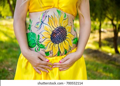 The artist painted flowers the belly pregnant women  On the body the woman painted sunflowers