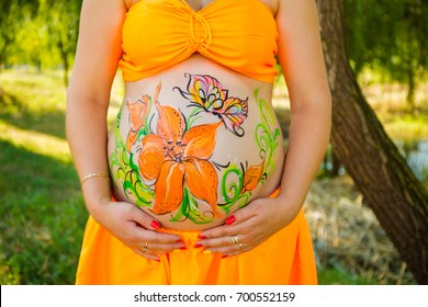 The artist painted flowers the belly pregnant women  On the body woman drawn lilies