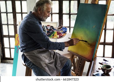 Artist painting artwork at workspace - Powered by Shutterstock
