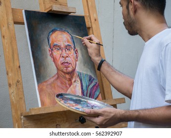 Artist painting portrait of asian man,oil color on canvas,which place on easel