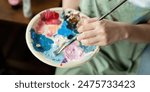Artist Painting in Workshop with Palette and Brush, Creating Colorful Artwork in Studio, Close Up of Hand and Paints, Creative Process, Artistic Expression, Professional Art Studio Environment