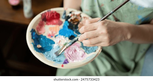 Artist Painting in Workshop with Palette and Brush, Creating Colorful Artwork in Studio, Close Up of Hand and Paints, Creative Process, Artistic Expression, Professional Art Studio Environment - Powered by Shutterstock