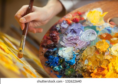 Artist Paints A Picture Of Oil Paint Brush In Hand With Palette Closeup