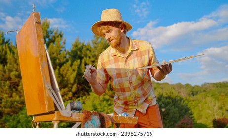 The artist paints a picture in the park. Green landscape, grass trees and flowers. The easel on which the painting stands. - Powered by Shutterstock