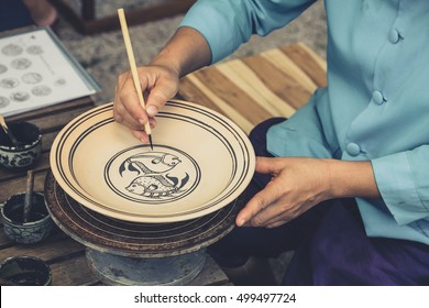 Artist sketch drawing paint pattern in earthenware, making of handcraft pottery in Sukhothai, Thailand. - Powered by Shutterstock