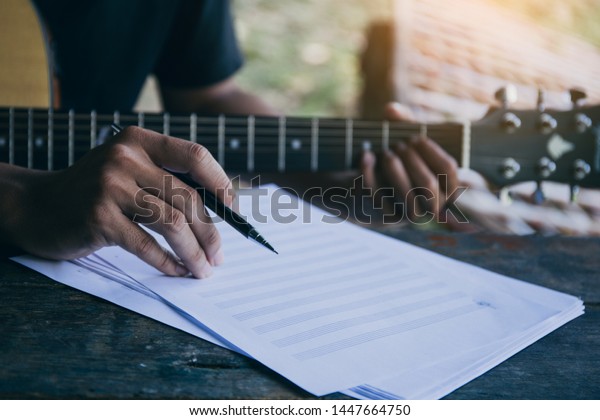 artist songwriter thinking writing notes,lyrics in\
book at studio.man playing live acoustic guitar relax chill.concept\
for musician creative.composer in work process.people relaxing\
time