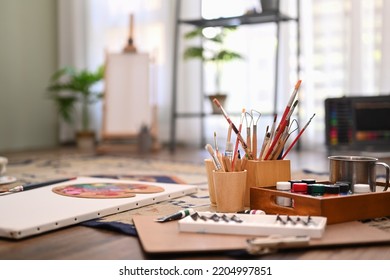 Artist Studio Interior With Canvas, Paint Brushes, Tubes Of Paint On Floor. Painters Room With Tools And Supplies