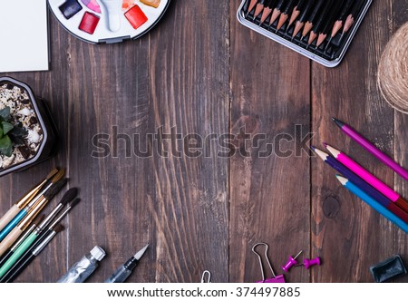 Artist supplies on the wooden table, top view