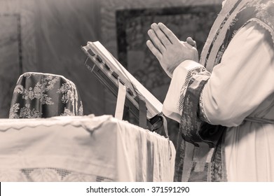 Artistic black and white dark vintage edit of a priest saying the extraordinary form, traditional latin tridentine rite Catholic mass. A detail. 