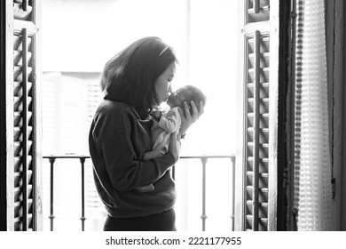 Artistic Black And White High Key Lifestyle Shot On Young And Happy Asian Chinese Woman Holding Adorable Newborn Baby Girl In Her Arms In Mother And Daughter Love Concept