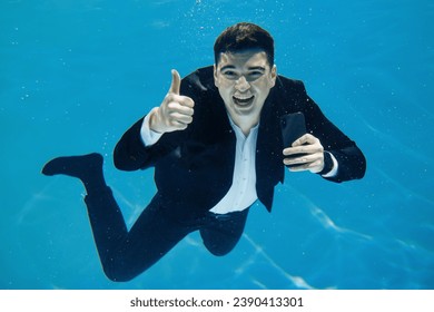 Artistic business concept. A man swims with a phone underwater on a blue background. - Powered by Shutterstock