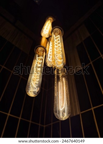 Artistic close-up of glowing vintage Edison light bulbs, showcasing their intricate filament designs. Ideal for interior design, lighting, and decor projects.