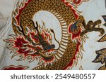 An artistic close-up of an ornately detailed dragon design on fabric. The vibrant colors and patterns evoke cultural richness and traditional Asian artistry, showcasing elegance and mythology