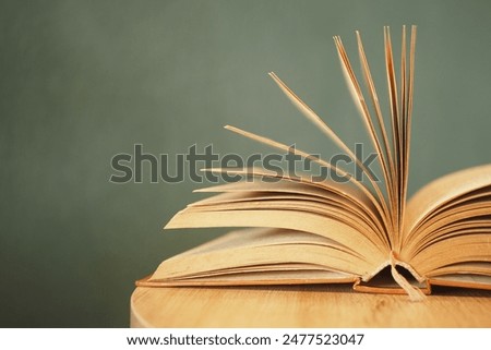 Artistic concept with open book pages on wooden surface, symbolizing literature and academia