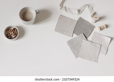 Artistic Craft Still Life. Beige Fabric Linen Swatches And Silk Ribbon Isolated On White Table Background. Cup Of Coffee, Bowl With Walnuts. Neutral Mood Board Project Flat Lay, Top. Fabric Samples.