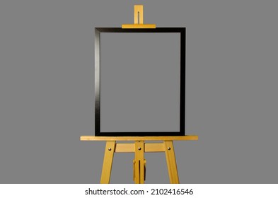 An artistic easel with a picture in black frame isolated on a gray background. The information frame is mounted on a tripod.
