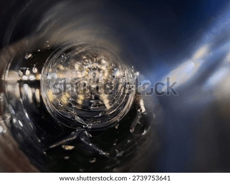 Artistic macro view through a plastic bottle with rainbow light refraction and motion blur. Dreamy abstract background with shimmering lens flares and water textures.