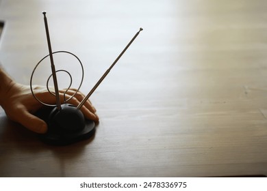 Artistic Metal Sculpture on Wooden Table - Abstract Home Decor with Hand Touching Modern Design - Powered by Shutterstock