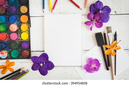 Artistic Mockup With Empty Notebook And Art Supplies Around Including Watercolor, Brushes And Calligraphy Pens. Blank Sketchbook On Wooden Desk.