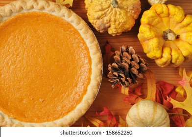 Artistic Photo Of Sweet Potato Pie, Or Pumpkin Pie With Autumn Leaves And Colorful Gourds